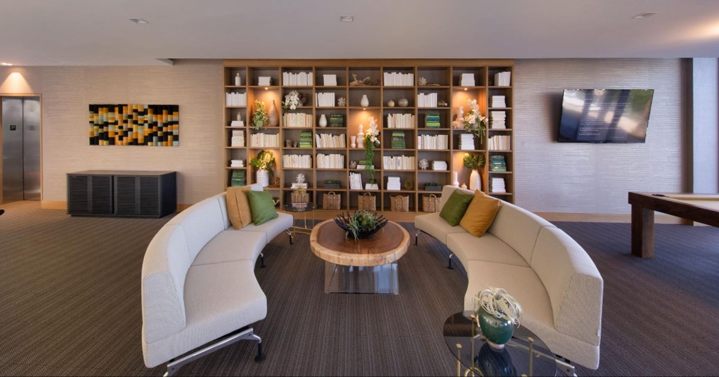 The Harbour Condo lounge with seating and library wall